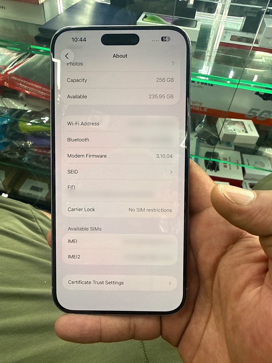 A real phone held up in the G-TECHPRO shop, its settings showing no SIM restrictions